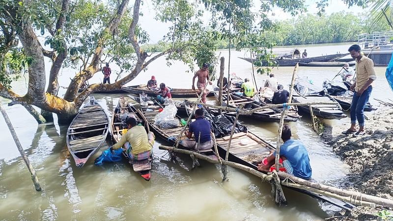 মাছ ও কাঁকড়া ধরতে সুন্দরবনে যেতে নৌকায় প্রয়োজনীয় জিনিসপত্র সাজিয়ে রাখছেন বনজীবী জেলেরা। রোববার সকালে সুন্দরবনের কাশিয়াবাদ ফরেস্ট স্টেশনের সামনে শাকবাড়িয়া নদীর পাড়ে